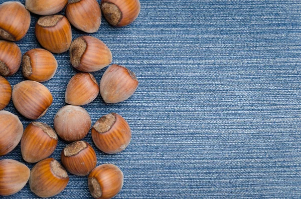 Heap of hazelnuts on jeans — Stock Photo, Image