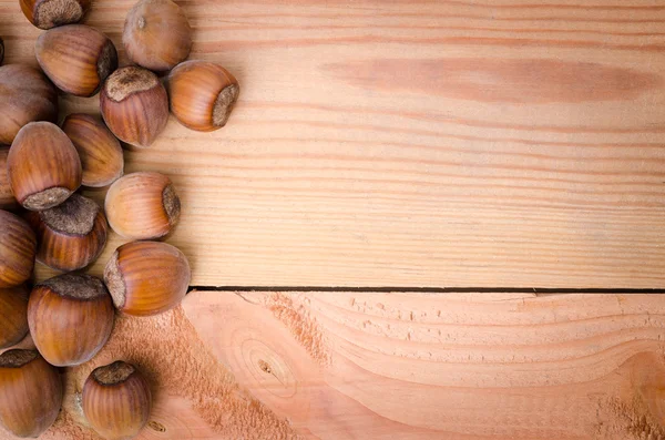 Heap of hazelnuts on wood — Stock Photo, Image