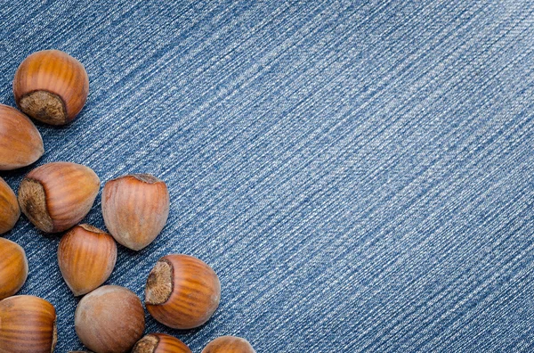 Hög med hasselnötter på jeans — Stockfoto