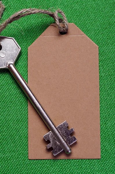 Tag attached to  silver key — Stock Photo, Image