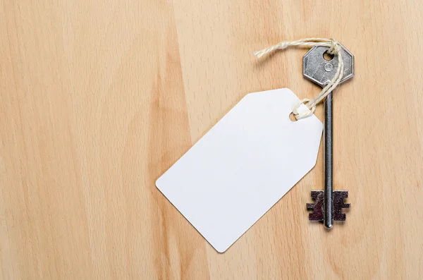 Paper tag attached to silver key — Stock Photo, Image