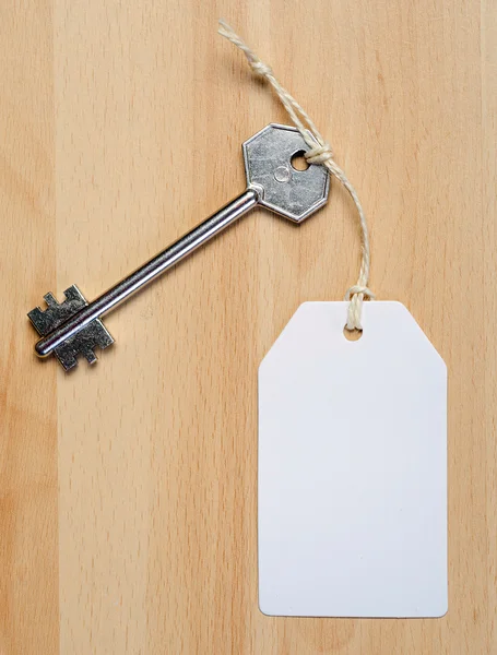 Paper tag attached to key — Stock Photo, Image