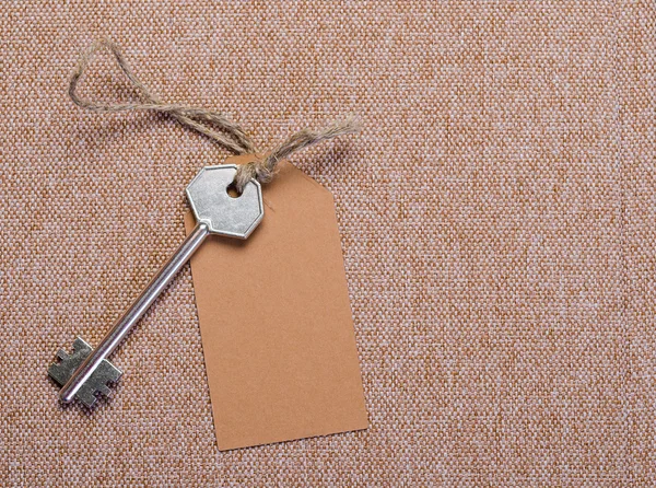 Paper tag attached to key — Stock Photo, Image