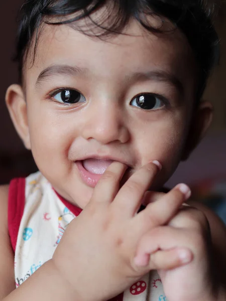 Um retrato vertical da cabeça de um bebê indiano adorável olhando para a câmera com foco seletivo nos olhos — Fotografia de Stock