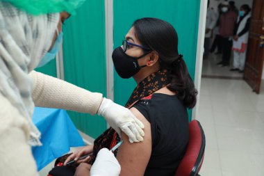 16 Ocak 2021, Kuganj, Bihar, Hindistan. MGM Tıp Fakültesi, Kuganj, Bihar 'da Covid 19' a karşı kovishield aşısı yaptıran maske takan bir kadın.