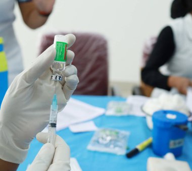 Eldivenli el şırıngayla aşı çiziyor. Corona virüs aşılama konsepti.