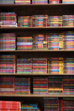 Kolkata, Hindistan, 12 Şubat 2021. Bir kitapçıda satılık bir sürü renkli hikaye kitabı ve çizgi romanı olan bir kitaplığın dikey fotoğrafı.