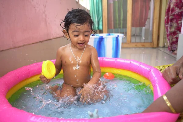 Indischer Baby Junge Genießt Bad Aufblasbarem Pool Mit Spritzwasser Und lizenzfreie Stockbilder
