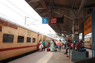 23 Mart 2021. Batı Bengal 'den Bardhaman. Yolcular platformda yerel bir trene binmeye hazır..