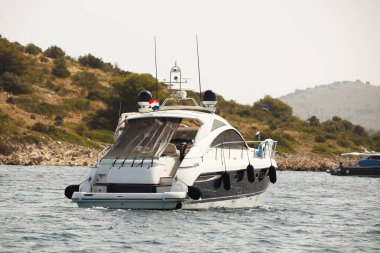 Mavi deniz ve kıyı boyunca çalışan motor yat. Adriyatik Denizi Akdeniz bölgesi. Hırvat ülke Dalmaçya Bölgesi. Aktif insanlar için su üzerinde özel eğlence.