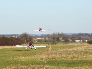 Çimen havaalanının pistinden aynı anda iki turbopervane uçağı kalkıyor. Hava gösterisinde boş zaman. Seyahat ve eğlence için özel havacılık. Havacılık endüstrisinin teknolojisi..