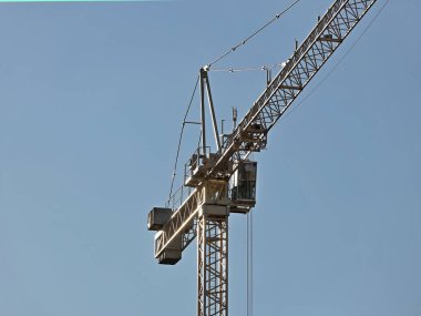 Kule vinçleri çok katlı bir binanın yapımı sırasında çalışır. Apartman sakinleri için yeni daireler ve ofisler için binalar. Yüksekken riskli iş. Ağır inşaat malzemeleri kaldırılıyor. Şehir Geliştirme.