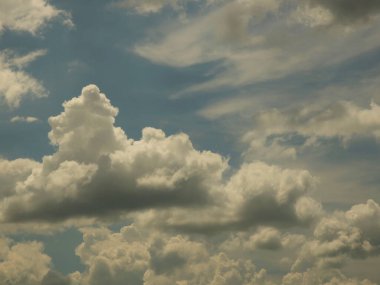 Kümülüs ve sirrus bulutlarıyla açık mavi gökyüzü. Güneşli bir hava. Neşeli bir ruh hali. Yüksek basınç. Temiz hava ekolojisi. Gaz halindeki bir su. Yağmur ve dolu kaynağı. Hava tahminleri.
