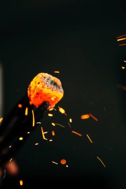 Cımbızlar nargile içmek için sıcak kırmızı kömür tutuyorlar.