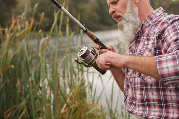 Cortado Tiro Homem Idoso Barbudo Ajustando Sua Vara Pesca Girando — Fotografia de Stock