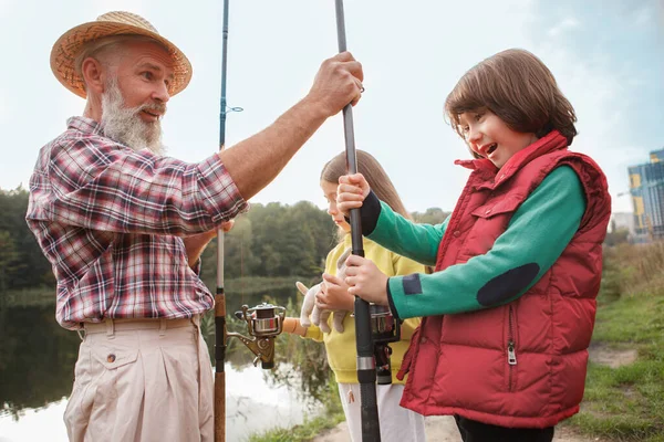 Feliz Joven Aspecto Emocionado Recibiendo Caña Pescar Abuelo —  Fotos de Stock