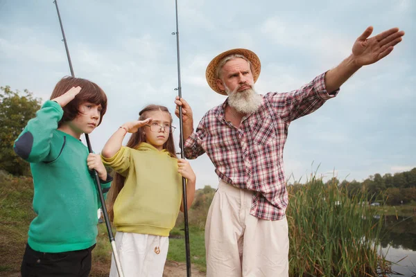 Hombre Mayor Enseñando Sus Nietos Sobre Pesca Aspecto Estricto Serio —  Fotos de Stock