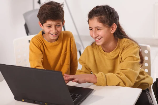 可爱的阿拉伯小男孩和他的少女笑着 一起在电脑上做在线项目 — 图库照片