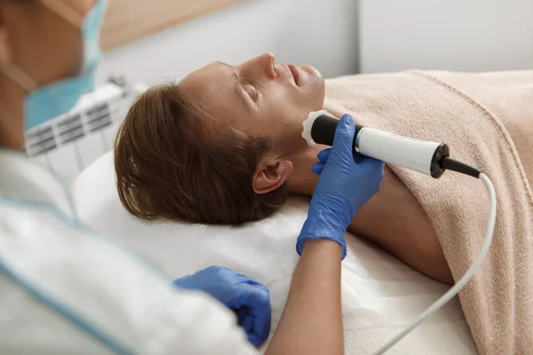 Cliente Masculino Relaxante Enquanto Recebe Tratamento Facial Por Cosmetician — Fotografia de Stock