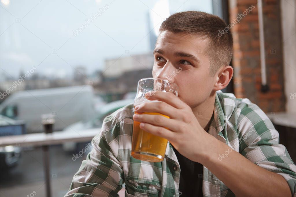 Close up of a man enjoying drinking craft beer at the pub, copy space