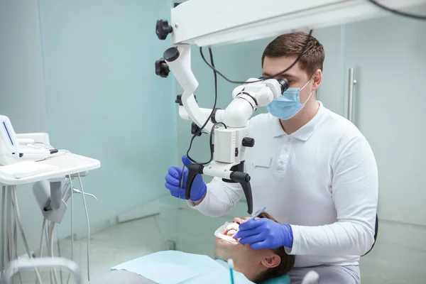Profesjonalny Dentysta Stosujący Mikroskop Stomatologiczny Leczący Zęby Pacjenta — Zdjęcie stockowe