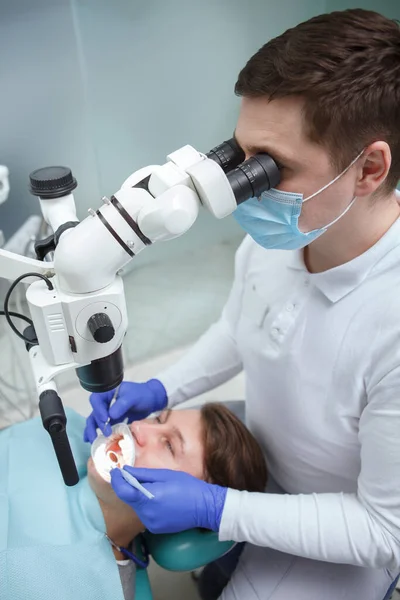 Pionowe Zdjęcie Dentysty Patrzącego Mikroskop Stomatologiczny Podczas Pracy — Zdjęcie stockowe