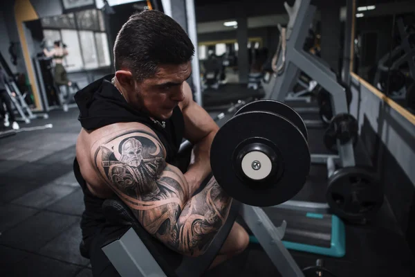 纹身健美运动员在体育工作室做二头肌卷曲 — 图库照片