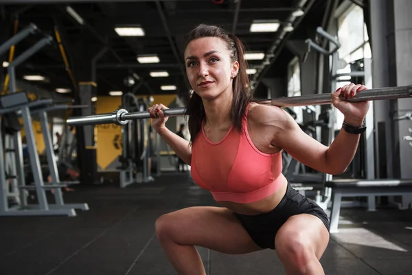 美しいです運動女性行いますBarbell Squatsにジム — ストック写真