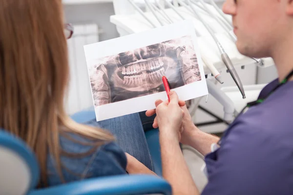 Cropped close up of a dentist discussing dental x-ray scan with his patient