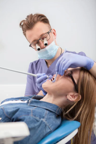 Pionowe Ujęcie Dentysty Noszącego Okulary Mikroskopowe Leczące Zęby Pacjenta — Zdjęcie stockowe
