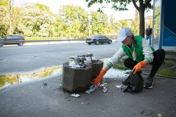 在城市街道上捡垃圾的年轻女人 抄袭空间 — 图库照片
