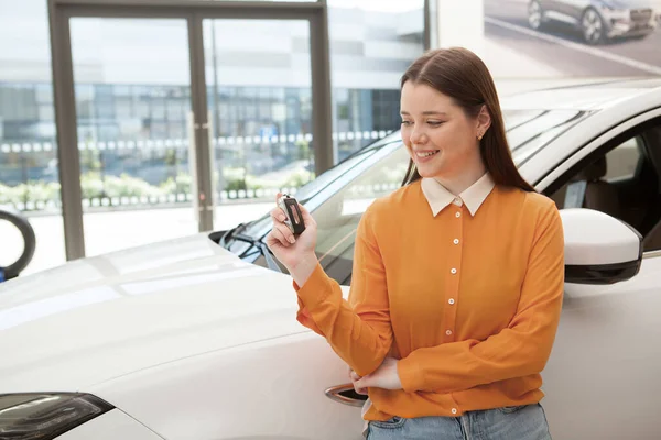 Mujer Joven Feliz Mirando Llave Del Coche Mano Apoyándose Automóvil —  Fotos de Stock