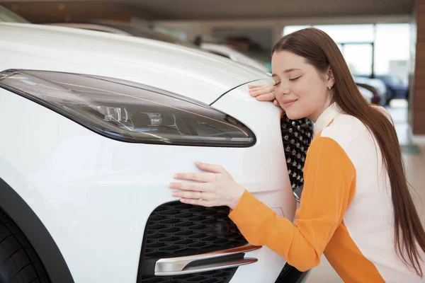 Bella Giovane Donna Che Abbraccia Sua Nuova Automobile Alla Concessionaria — Foto Stock