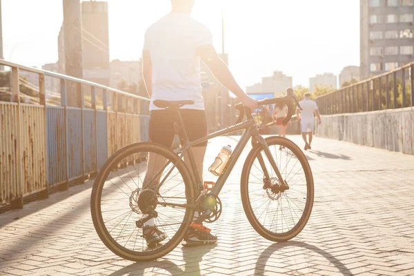 여름날 도시의 거리를 자전거로 돌다가 자전거타는 사람의 뒷모습 — 스톡 사진