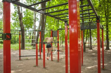 Seçici odak noktası beden eğitimi çocuk parkı ekipmanları, adam arka plandaki çubuklarda dalış yapıyor