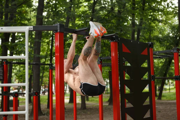 Strong Sportsman Doing Toes Bar Abdominal Exercise Outdoors — Stock Photo, Image