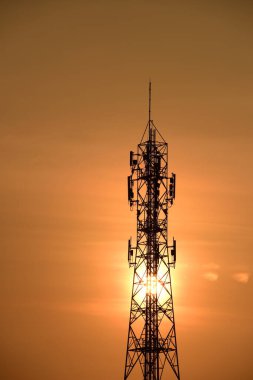 Telekomünikasyon Kulesi Antenleri Yüksek Kutup Sinyal İletimi Hem Kablosuz Telefon, hem de Kablosuz İletişim Anteni Gündoğumu Parlak Gökyüzü ile. Turuncu gökyüzü antenli Telekomünikasyon Kulesi.