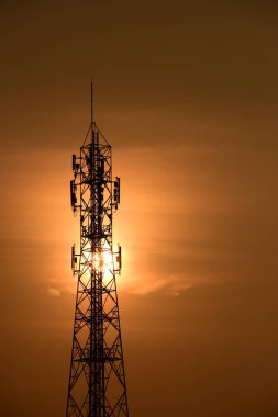Telekomünikasyon Kulesi Antenleri Yüksek Kutup Sinyal İletimi Hem Kablosuz Telefon, hem de Kablosuz İletişim Anteni Gündoğumu Parlak Gökyüzü ile. Turuncu gökyüzü antenli Telekomünikasyon Kulesi.