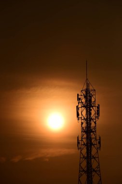 Telekomünikasyon Kulesi Antenleri Yüksek Kutup Sinyal İletimi Hem Kablosuz Telefon, hem de Kablosuz İletişim Anteni Gündoğumu Parlak Gökyüzü ile. Turuncu gökyüzü antenli Telekomünikasyon Kulesi.