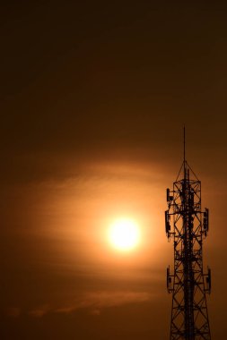 Telekomünikasyon Kulesi Antenleri Yüksek Kutup Sinyal İletimi Hem Kablosuz Telefon, hem de Kablosuz İletişim Anteni Gündoğumu Parlak Gökyüzü ile. Turuncu gökyüzü antenli Telekomünikasyon Kulesi.