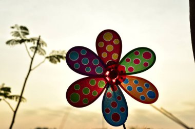 close up of a colorful pinwheel at sunset time