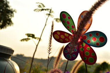 close up of a colorful pinwheel at sunset time