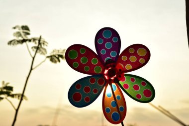 close up of a colorful pinwheel at sunset time