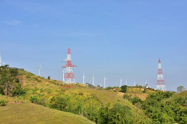 Wind turbines and high voltage towers in mountains