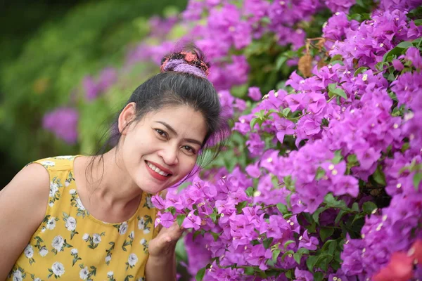 庭でピンクの花の近くにポーズアジアの女性 — ストック写真