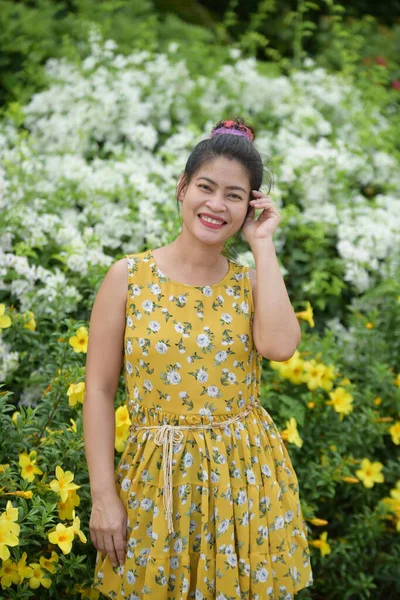 Azji Kobieta Pozowanie Żółte Kwiaty Ogrodzie — Zdjęcie stockowe