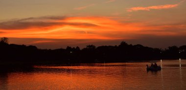 Gün batımından sonra güzel sarı gökyüzü, Formal Garden 'da batan bir güneşin resmi. Park et. Güzel Bahçe