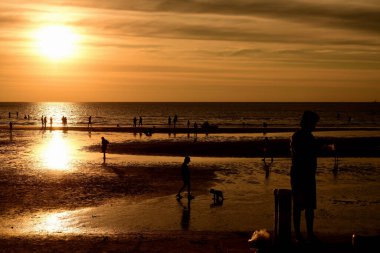  Gün batımında güzel sahil manzarasında birçok insan gün batımından önce oynamak için sahile gelirler..