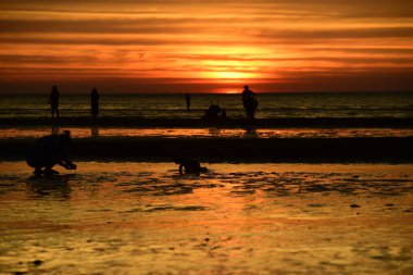  Gün batımında güzel sahil manzarasında birçok insan gün batımından önce oynamak için sahile gelirler..