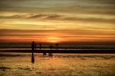  Gün batımında güzel sahil manzarasında birçok insan gün batımından önce oynamak için sahile gelirler..